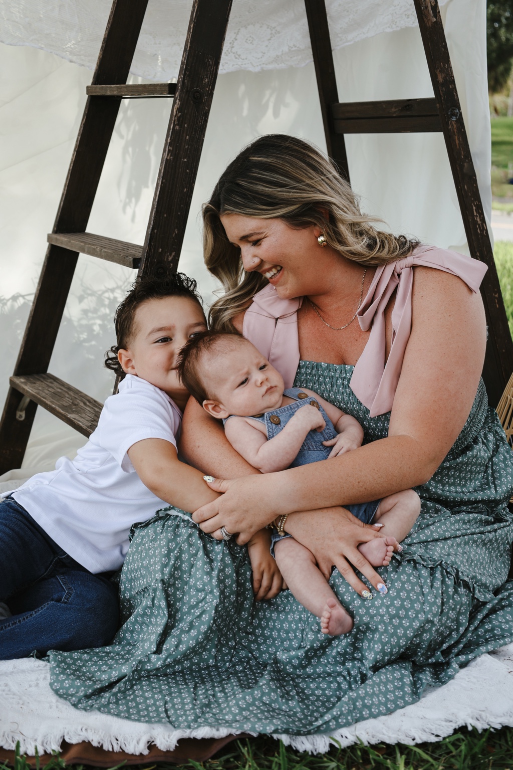 Mother cuddling her children outdoors